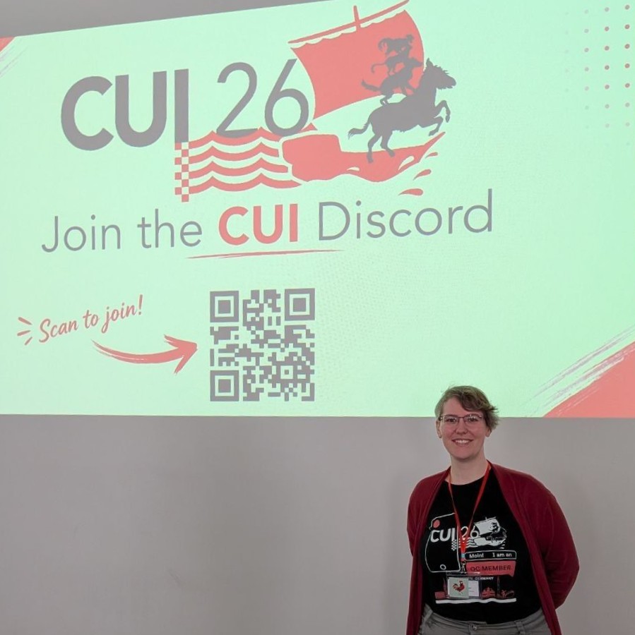 A photo of Verena Traubinger in front of the projected CUI 2026 logo on a wall.